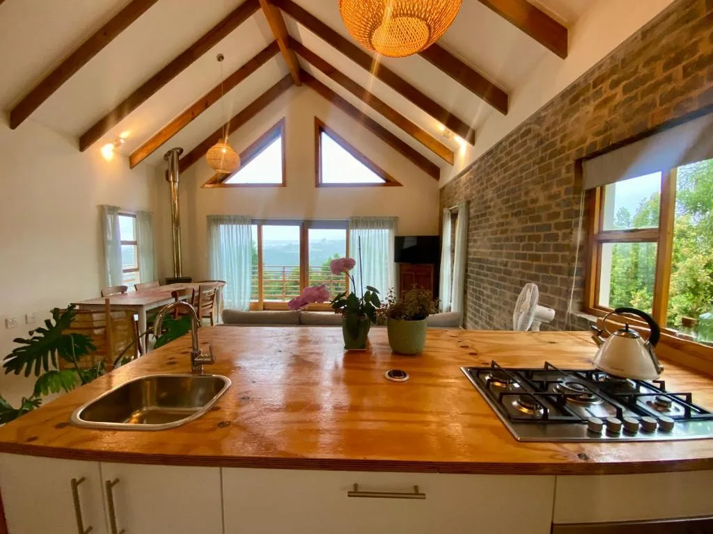 Modern kitchen with wooden countertop, gas cooktop, and scenic mountain views