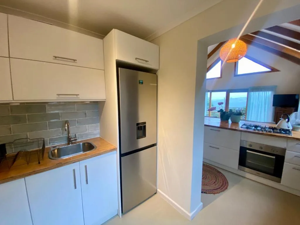 Modern white kitchen with stainless steel appliances and ocean view windows