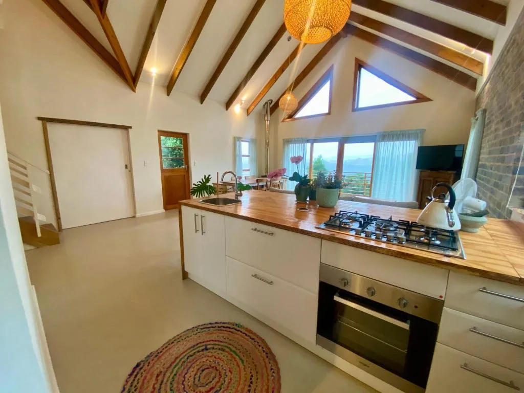 Modern open-plan kitchen with island, gas cooktop, and scenic views