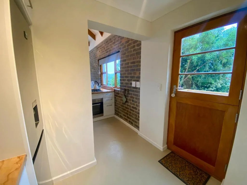 Modern kitchen with brick accent wall and window overlooking garden greenery