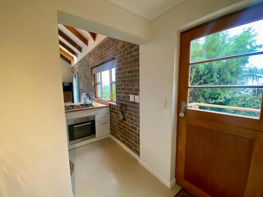 Modern kitchen with brick feature wall, built-in oven, and garden views