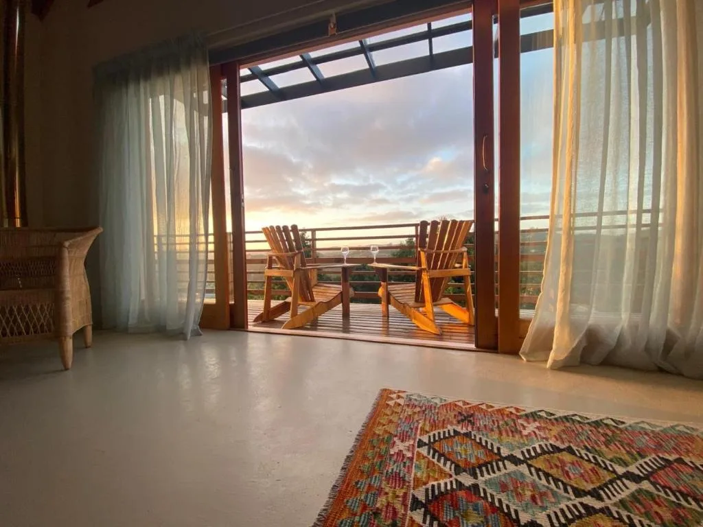Spacious lounge with open glass doors overlooking scenic sunset deck views
