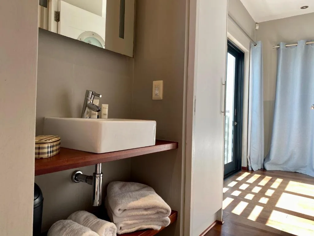 Modern bathroom vanity with white rectangular sink and mirror