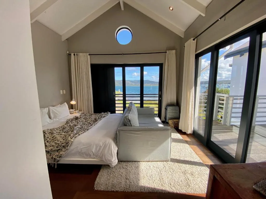 Bright bedroom with ocean views through large glass doors and windows