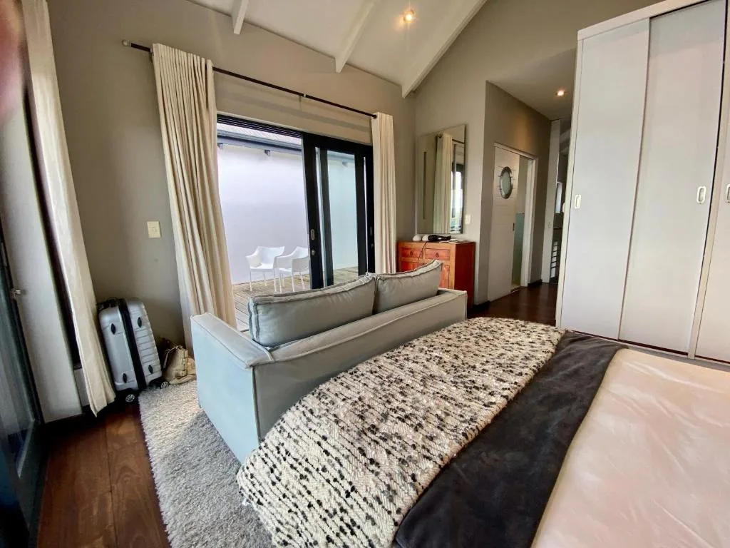 Spacious bedroom with king bed, lounge seating, and ocean view doors