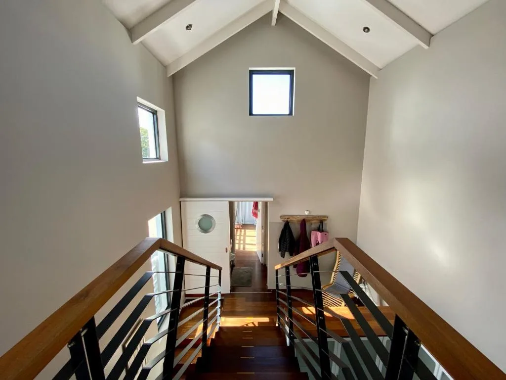 Bright mezzanine hallway with vaulted ceiling and wooden railings