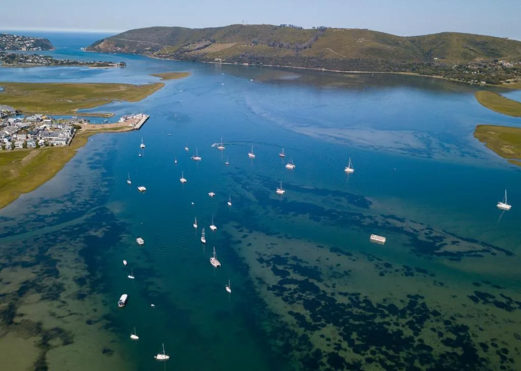 Aerial view of Knysna Lagoon with moored boats and surrounding hills