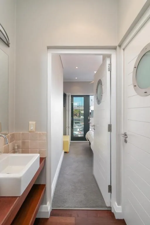 Modern bathroom with white vanity sink and open doorway to hallway