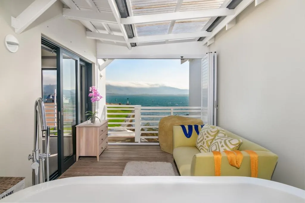 Covered patio with seating overlooking lagoon and mountains beyond