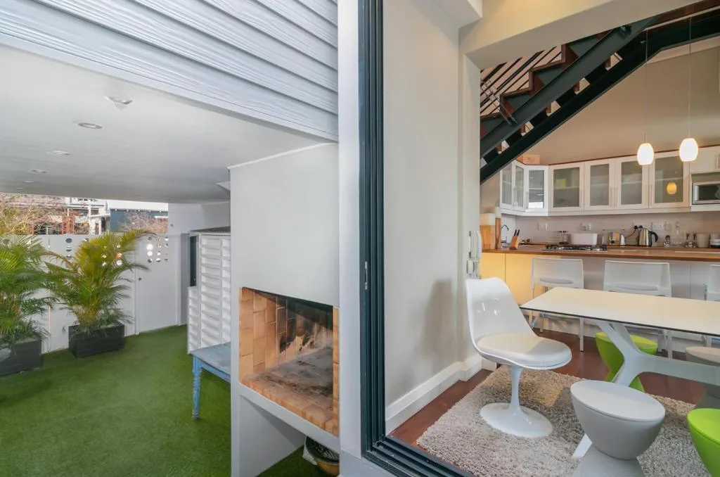 Modern living space with fireplace, dining area, and open kitchen visible