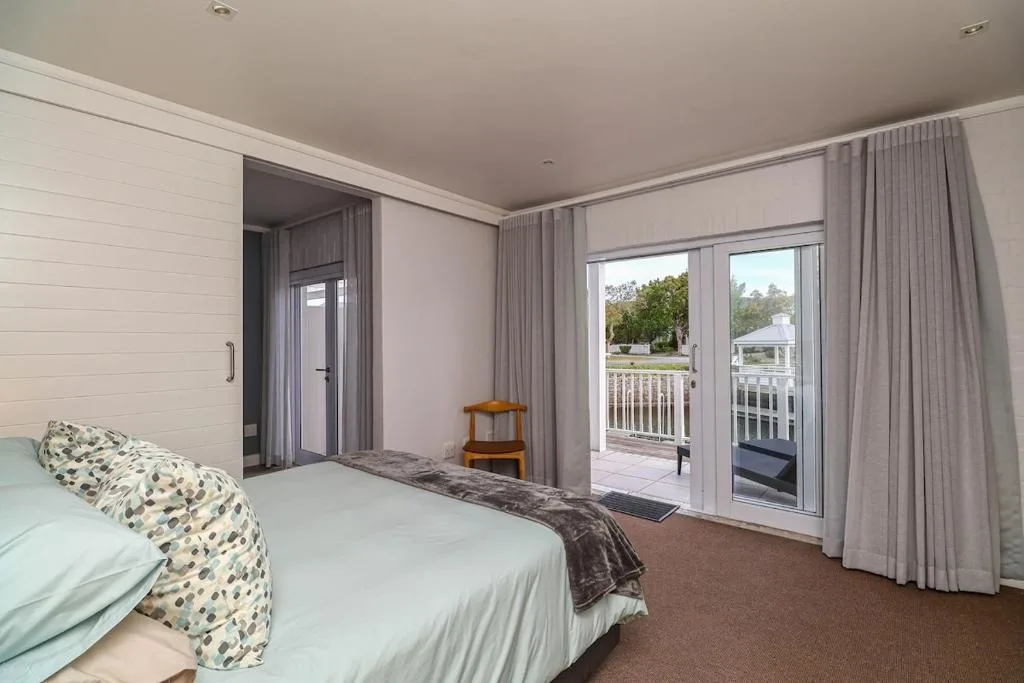 Spacious master bedroom with queen bed and garden view through sliding doors