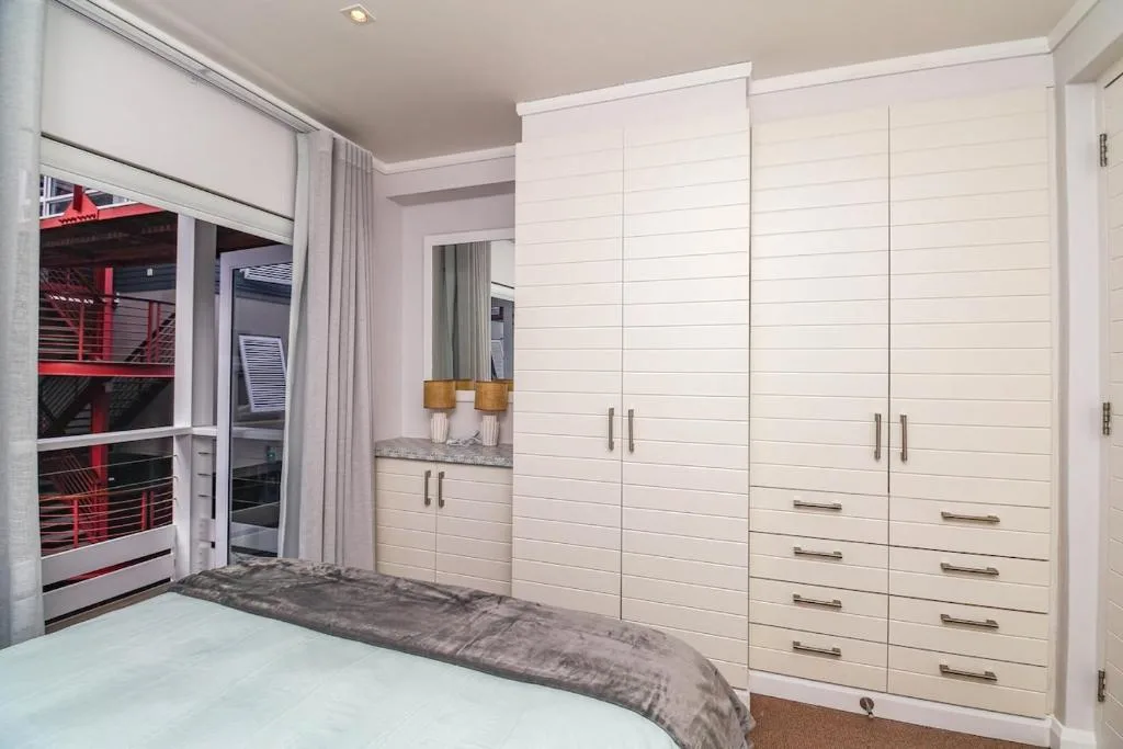 Modern bedroom with white built-in wardrobe and mirrored vanity