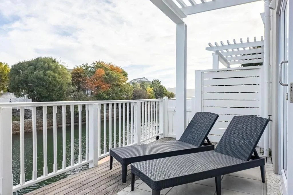 Modern deck with two lounge chairs overlooking lush garden landscape