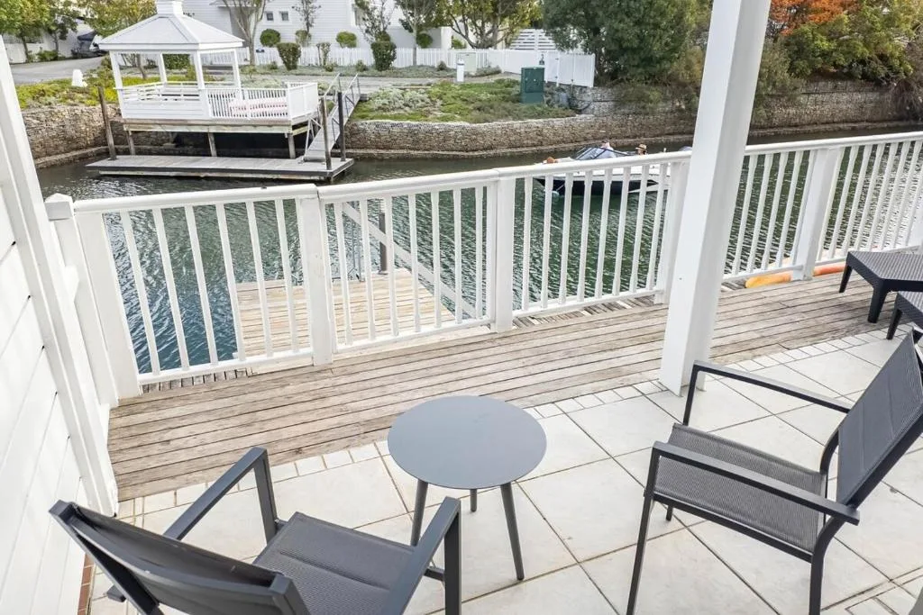 Waterfront deck with seating overlooking canal and white railings