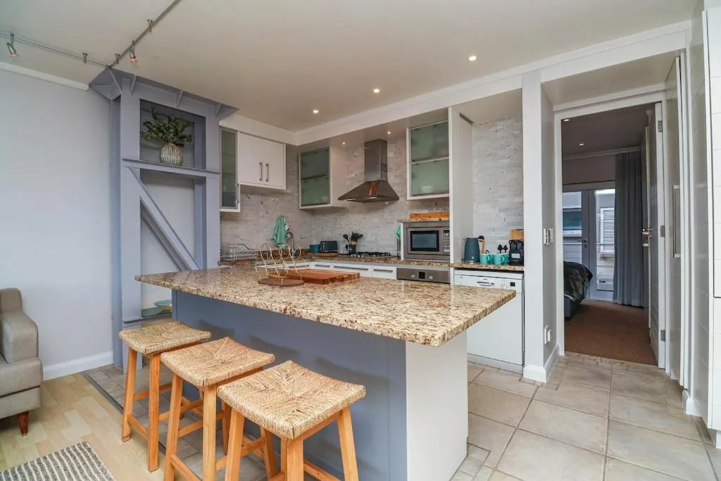 Modern kitchen with granite countertop island and wooden bar stools