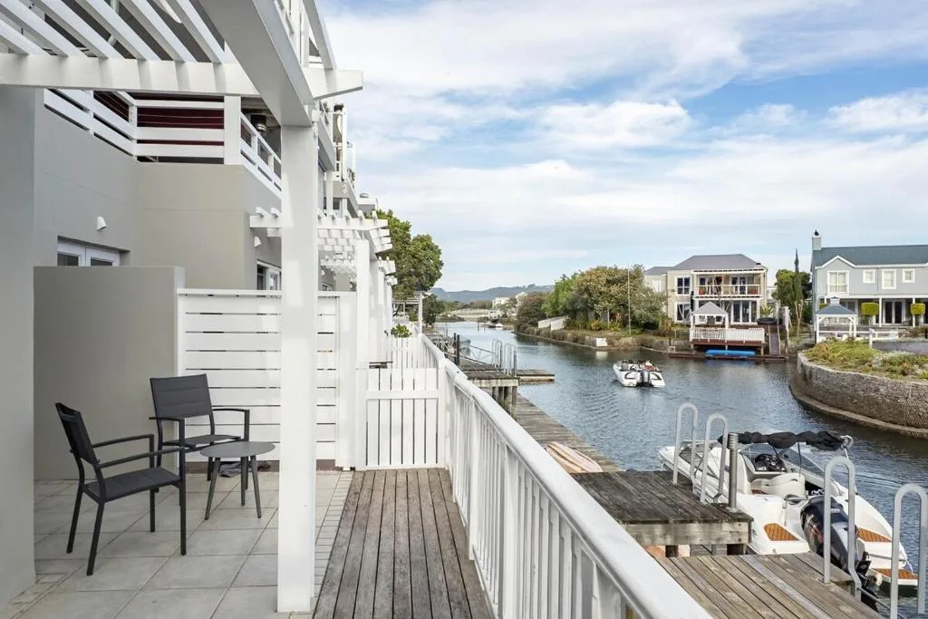 Waterfront view of Knysna lagoon with boats and residential homes across the water