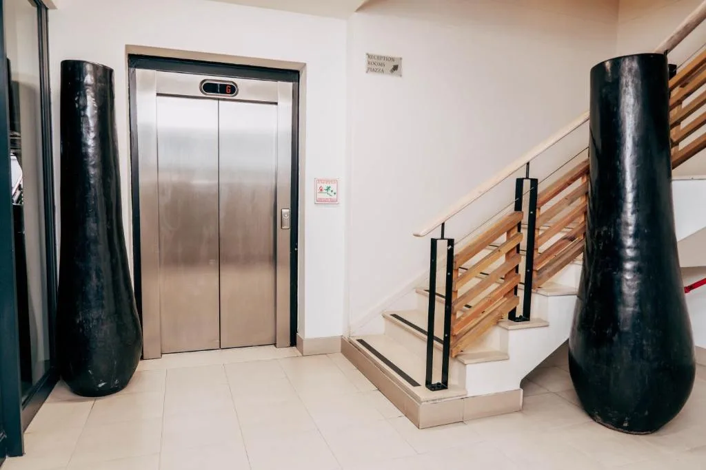 Modern building entrance with elevator and wooden staircase