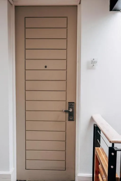 Modern apartment entrance door with horizontal slats and unit number 209