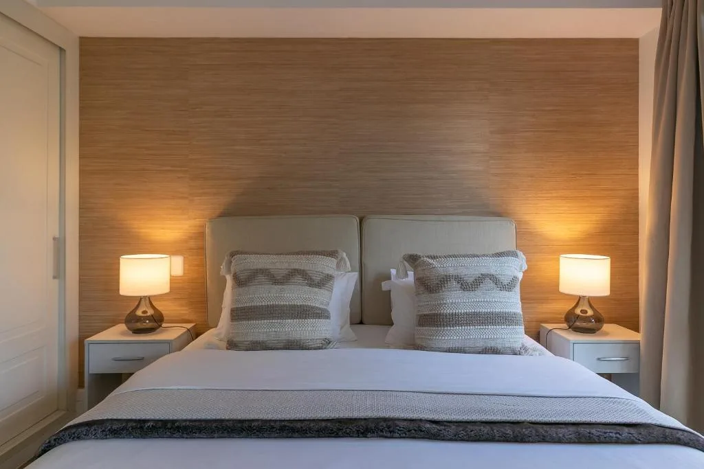 Modern bedroom with upholstered headboard and warm ambient lighting from bedside lamps