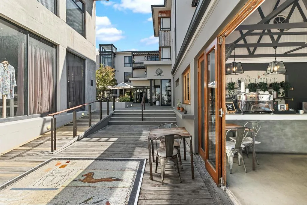 Modern covered deck with dining table and coffee shop access