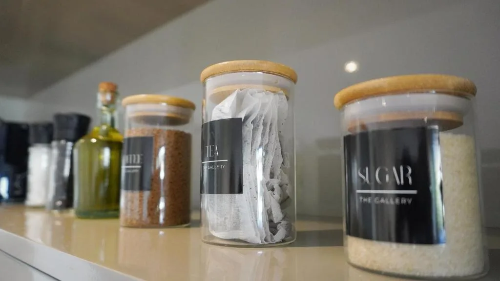 Kitchen storage jars with wooden lids arranged on white counter