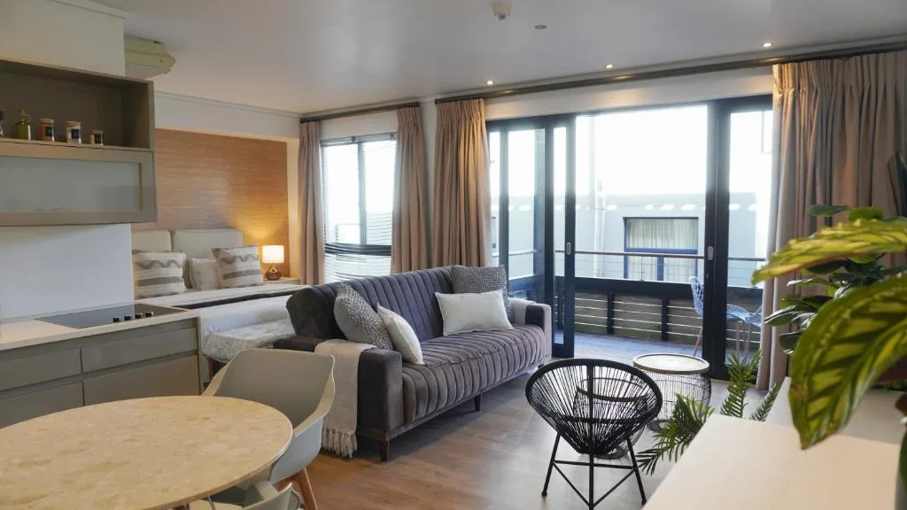 Modern lounge with striped sofa, dining table, and ocean view balcony