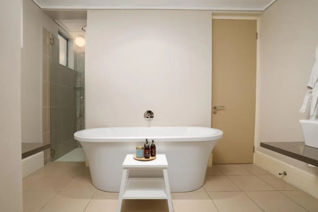 Modern freestanding bathtub with rainfall shower and spa amenities