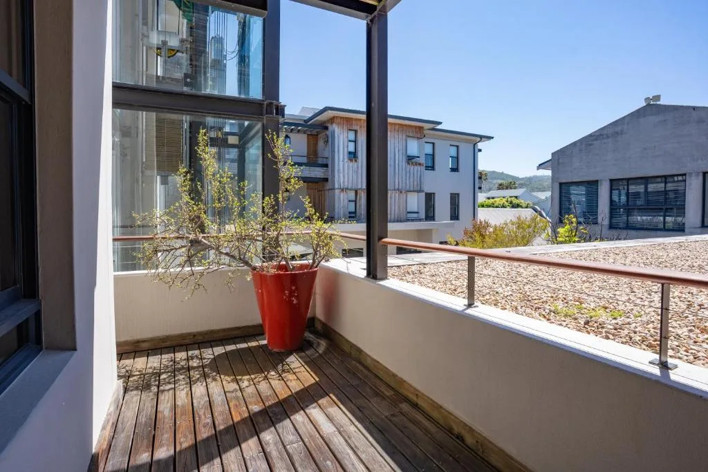 Modern wooden deck with potted plant and water views beyond