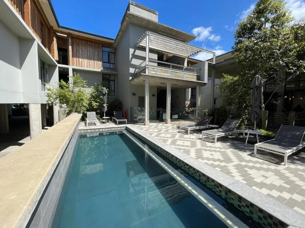 Modern swimming pool with loungers and contemporary house architecture