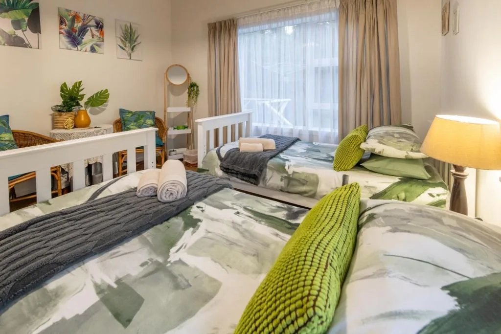 Bright family bedroom with multiple beds, green accents, and natural light