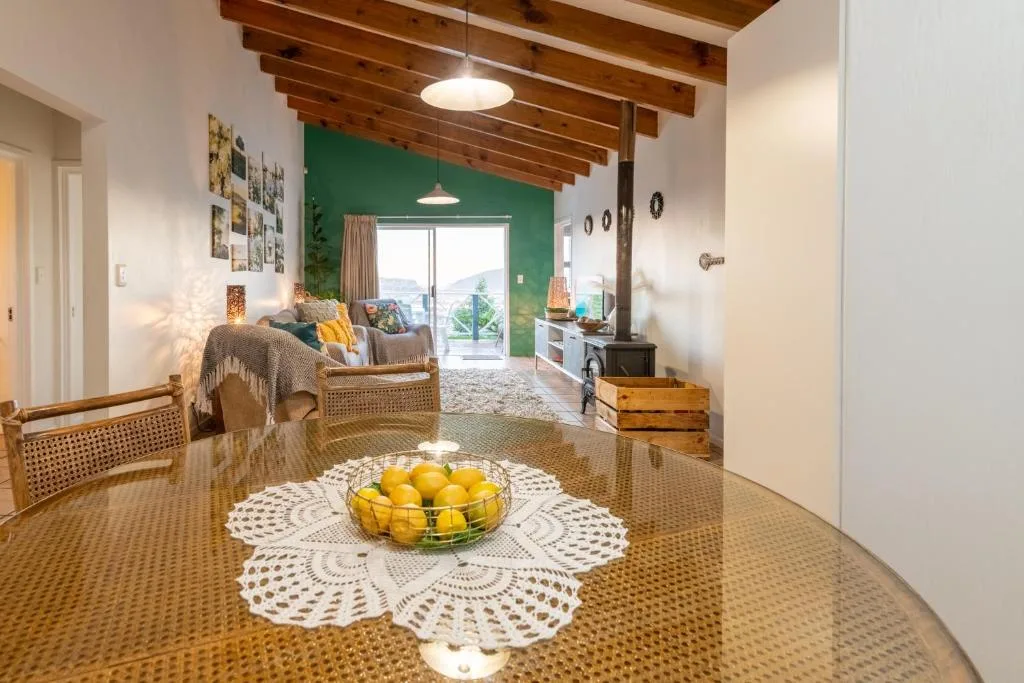 Dining table with fresh lemons and woven chairs in bright open-plan space
