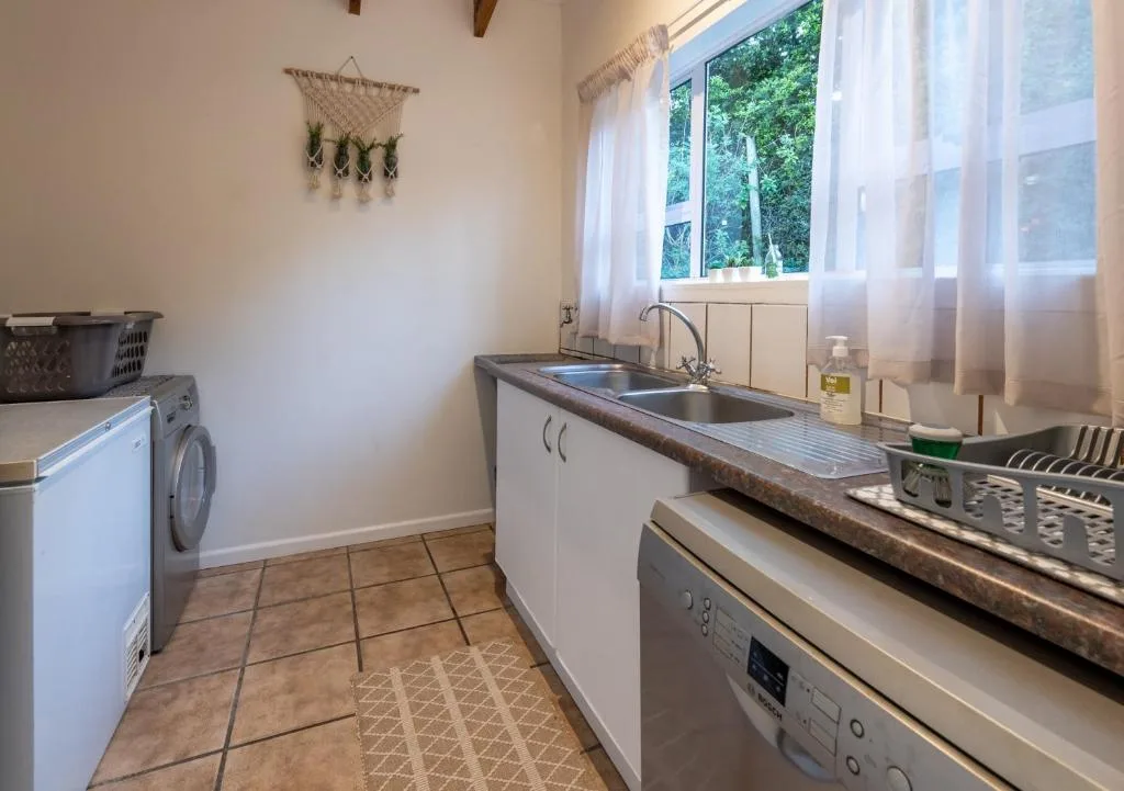 Modern kitchen with double sink, stove, and washing machine appliances