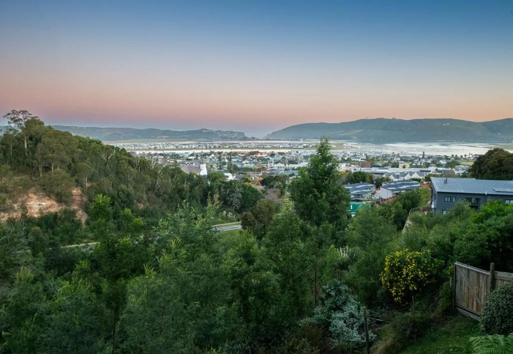 Elevated view of Knysna town, lagoon, and surrounding mountains at sunset