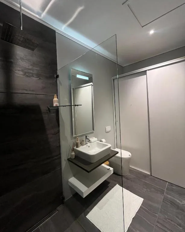 Modern bathroom with vessel sink, walk-in shower, and contemporary fixtures