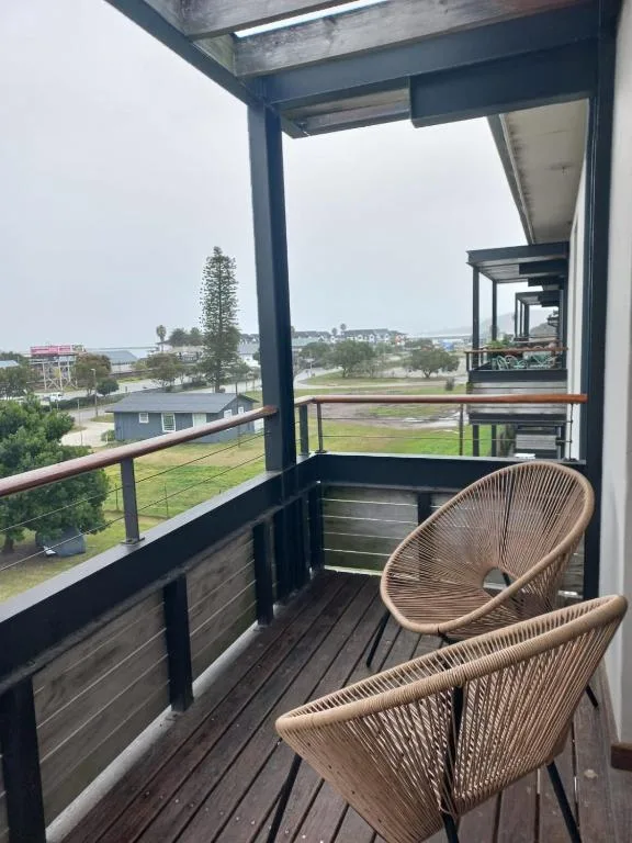 Modern balcony with woven chairs overlooking Knysna town and lagoon