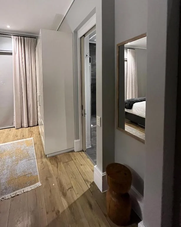 Modern hallway with wooden floors, gray walls, and mirrored doors