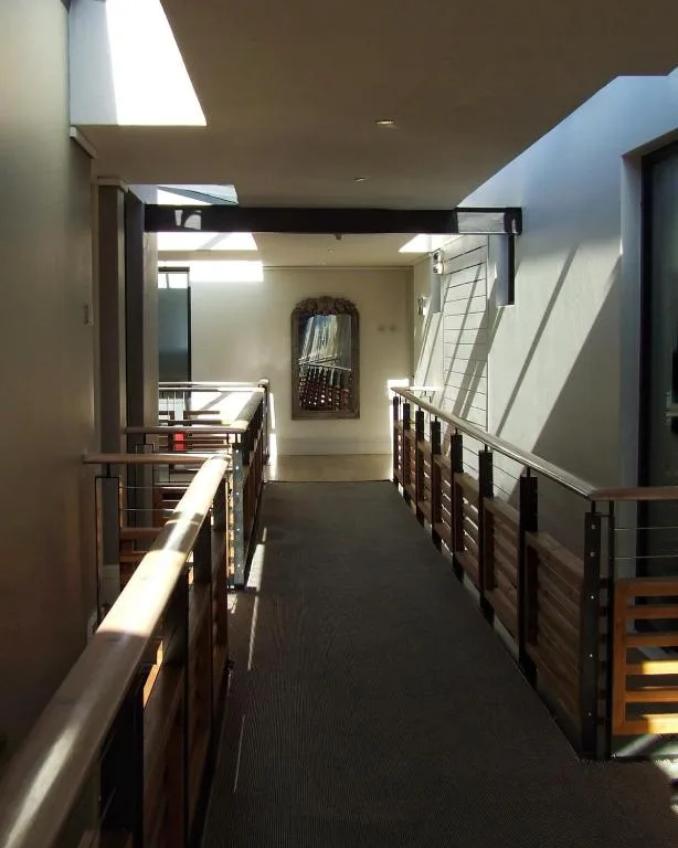 Modern interior hallway with skylights and wooden railings, contemporary design
