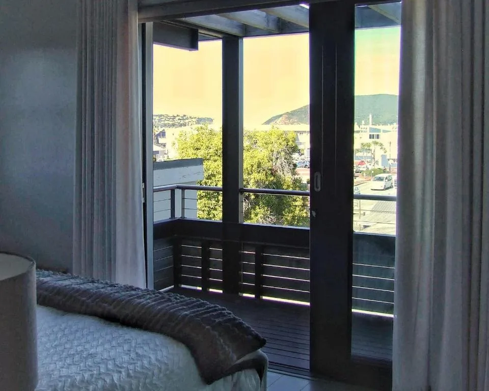 Scenic coastal town and hillside views through modern glass sliding doors