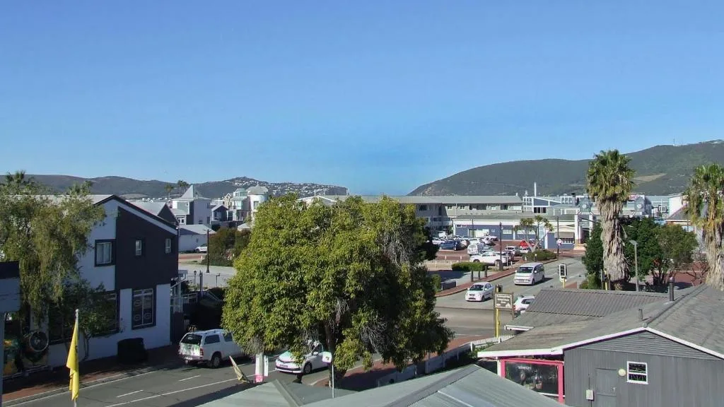 Coastal town panorama with mountains and harbor visible beyond residential buildings