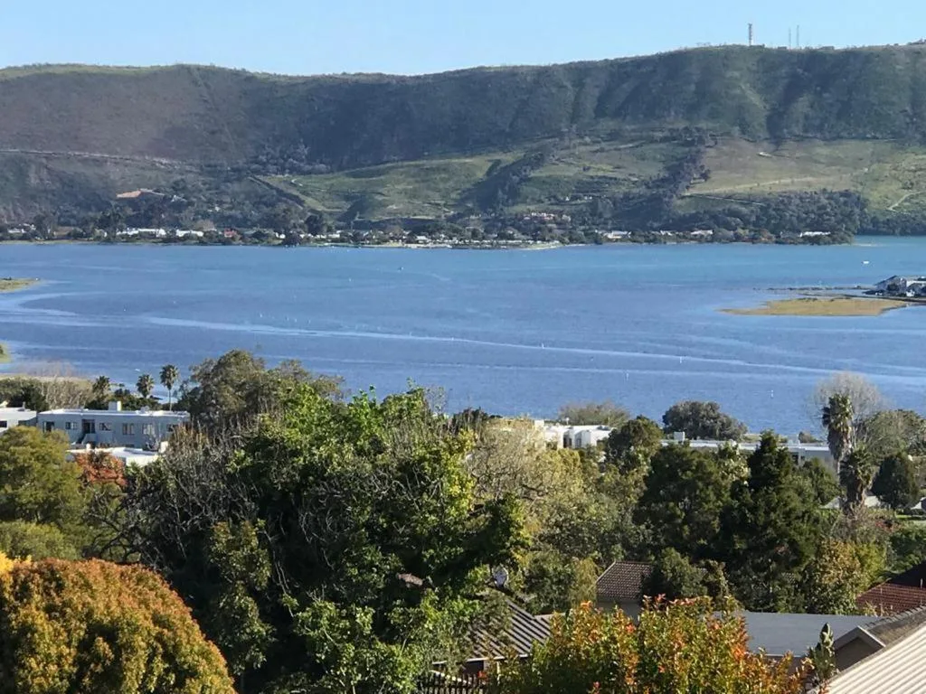 Scenic lagoon view with mountains, village, and sparkling blue water beyond