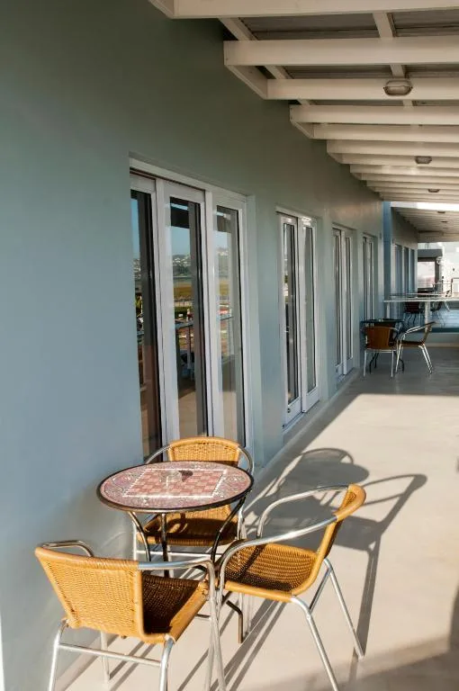 Covered deck with outdoor seating table and chairs overlooking garden route