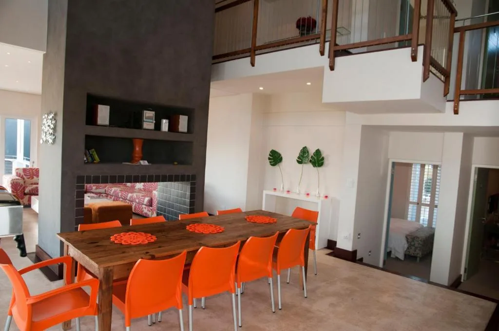 Modern dining area with wooden table and bright orange chairs