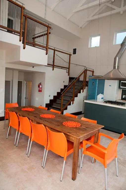 Spacious dining area with wooden table and orange chairs, open-plan layout