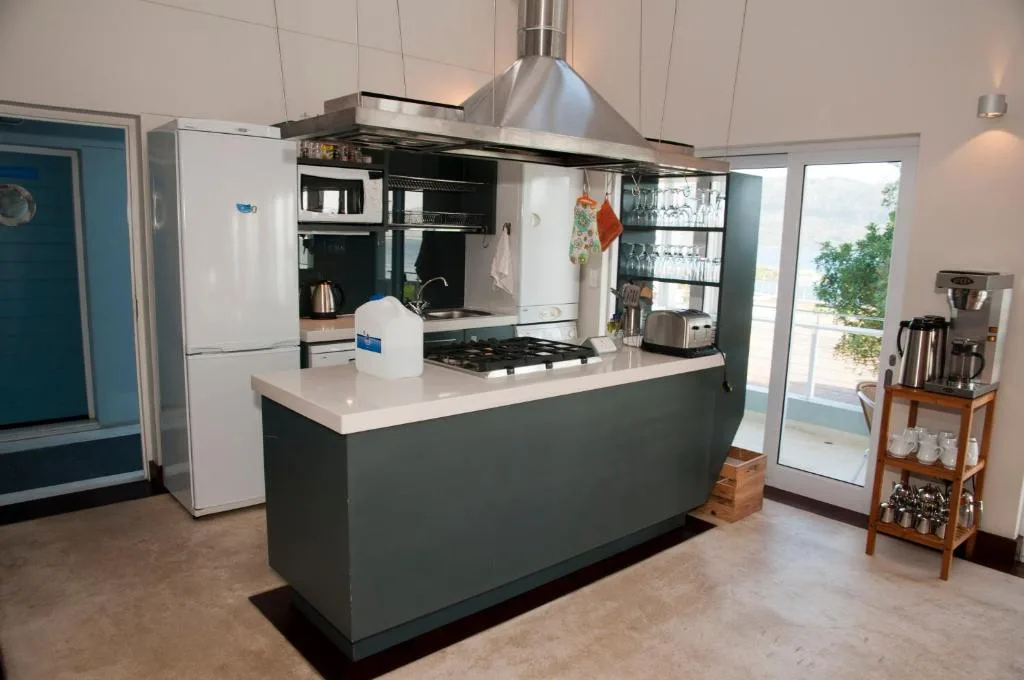 Modern kitchen with island bench, gas cooktop, and stainless steel hood
