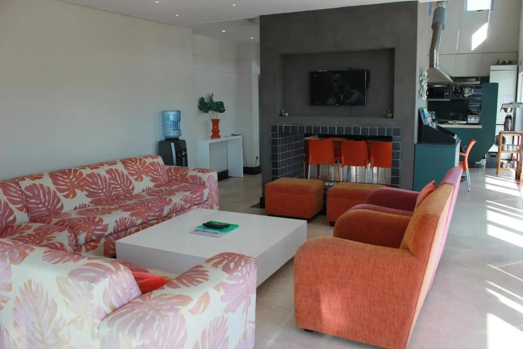 Modern living room with patterned sofas, fireplace, and wall-mounted TV