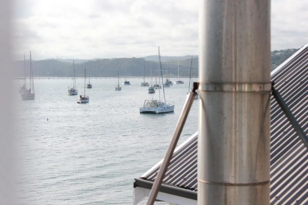 Scenic water view of sailboats anchored in Knysna Lagoon with mountains beyond