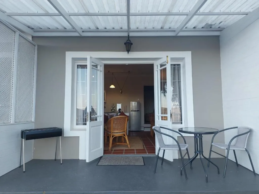 Covered patio with bistro table, chairs, and interior access doors