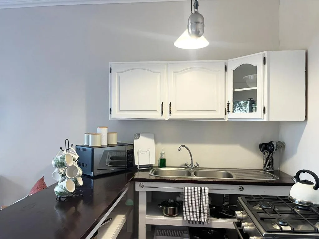 Modern kitchen with white cabinetry, gas stove, and stainless steel sink