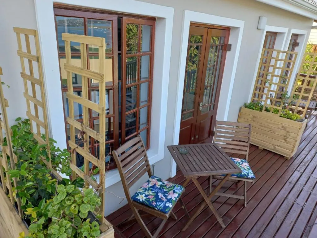 Wooden deck with outdoor seating, lattice screens, and potted plants