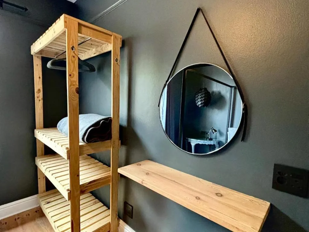 Modern bedroom with wooden bunk bed frame and round wall mirror